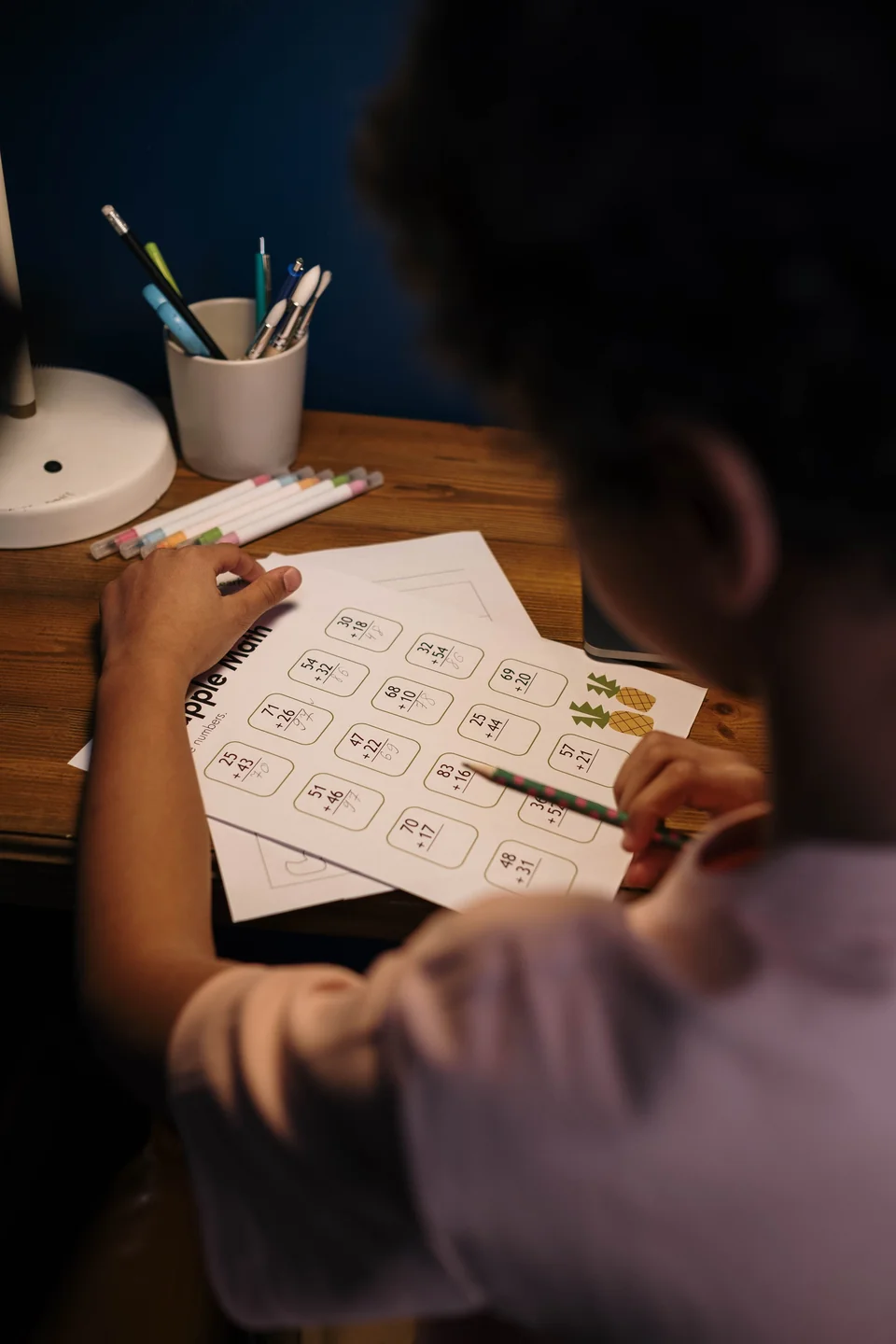 Anak belajar mengerjakan soal matematika di meja